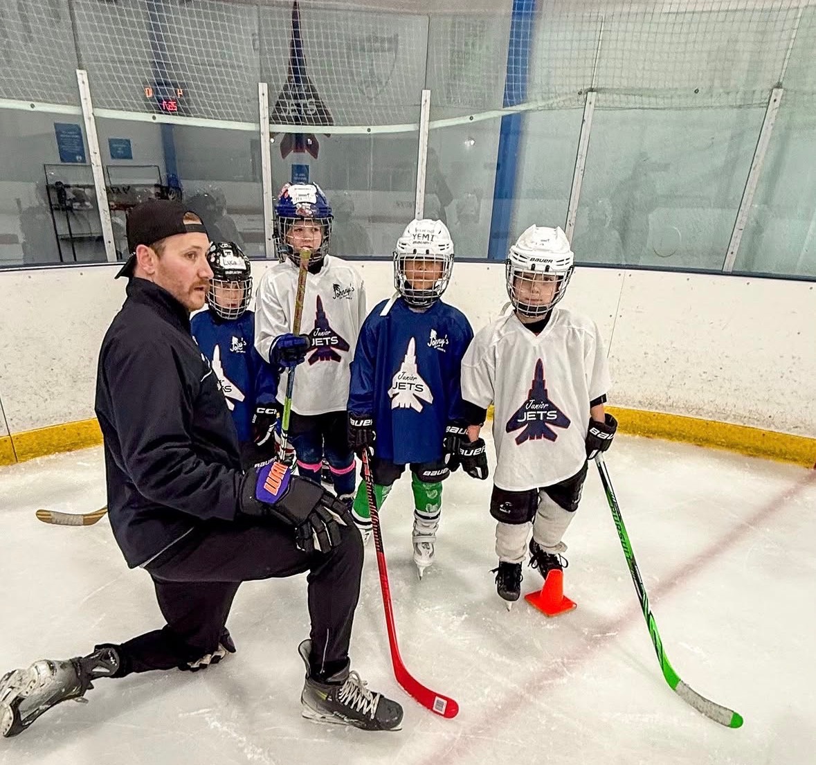 Ryan Devine leading a group hockey lesson with youth players